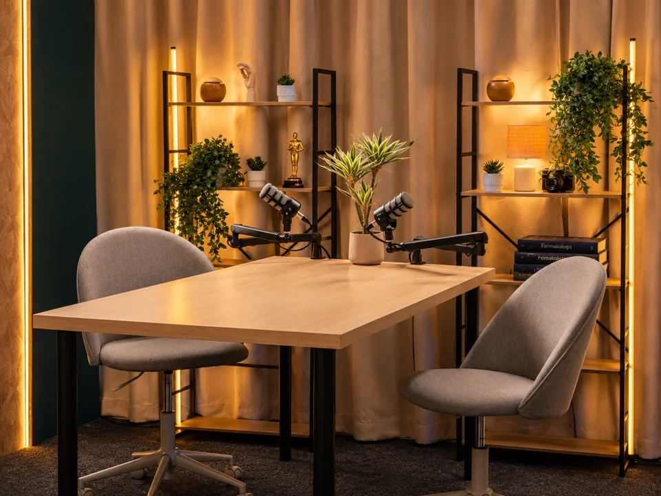 Stół z mikrofonami i fotelami w studiu podcastowym